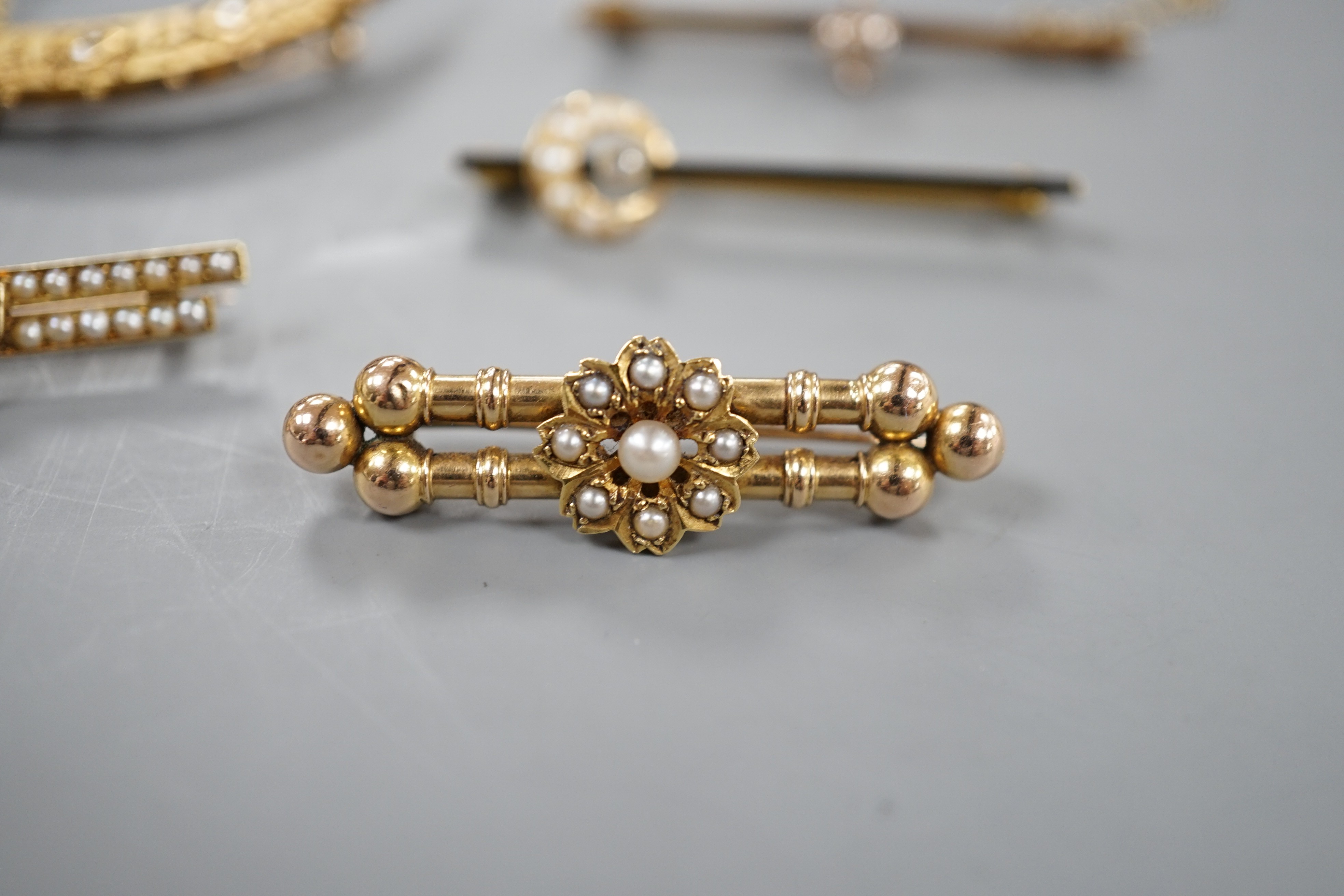Two assorted late 19th/early 20th century 15ct, diamond and seed pearl set bar brooches including crescent, 53mm and enamel and crescent, gross7 grams, and three other bar brooches, diamond set and seed pearl set, gross